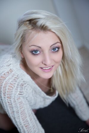 Beautiful blonde with blue eyes removes her sweater and panties