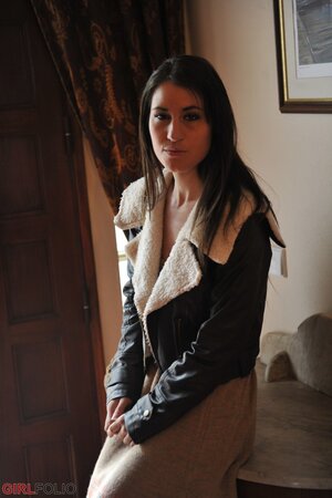 Brunette beauty Jess West casually disrobes and stands naked in the living room