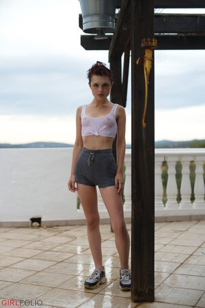 Short red-haired girl with freckles smokes after getting wet