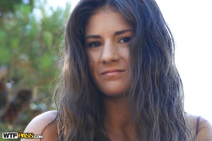 Submissive brunette in a bikini shows her goodies on a hill