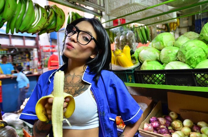 Tattooed Marly Romero licks banana naughty in public