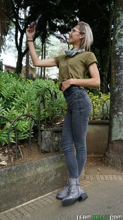 Veronica Leal poses on hood in green shirt and tight jeans