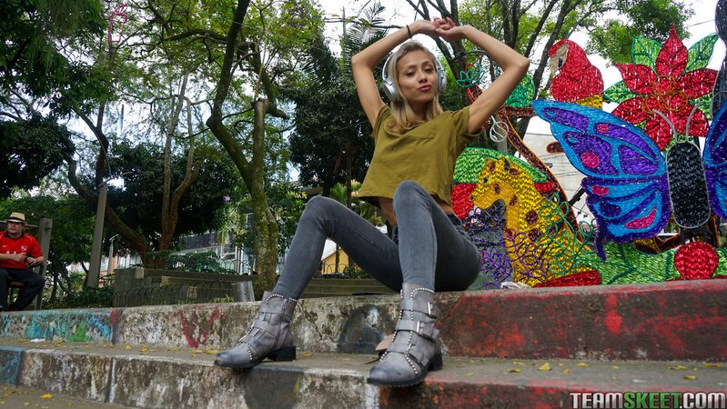 Veronica Leal poses on hood in green shirt and tight jeans