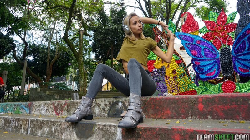 Veronica Leal poses on hood in green shirt and tight jeans