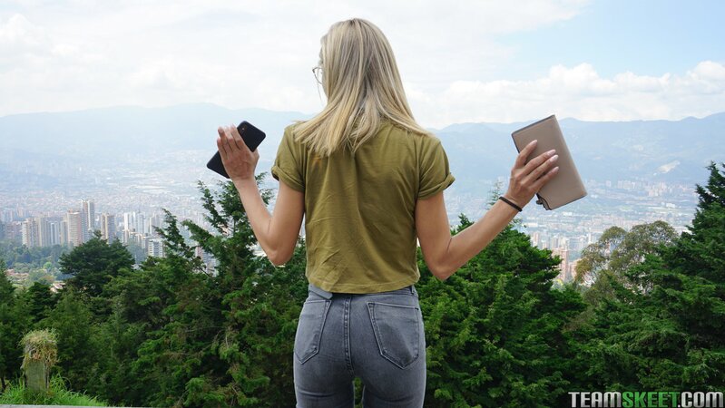 Veronica Leal poses on hood in green shirt and tight jeans