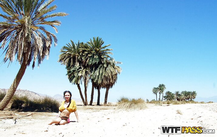 Brunette in sunglasses poses barely clothed big tits outdoors