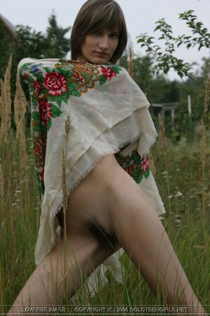 Skinny brunette is happy to play in a field and show you her bod