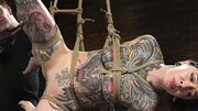 Tattooed wench is tied up and fingered in the BDSM room